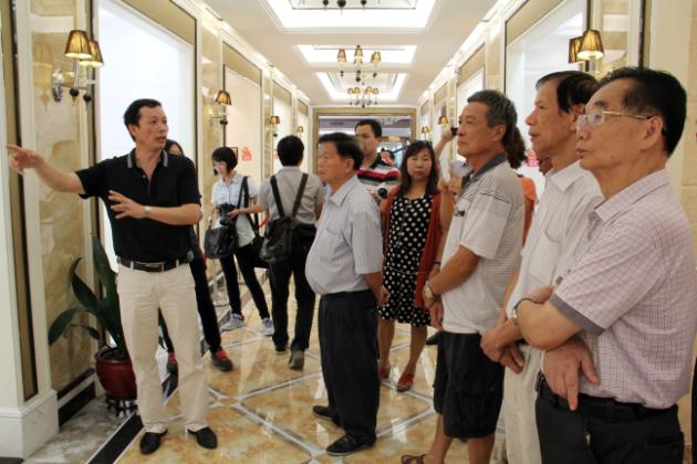 图3、91免费版视频市场总监霍达炎（左一）在为参观者介绍釉面砖展示空间.jpg